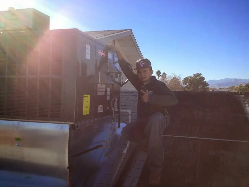 HVAC technician performing Air Duct Repair on a rooftop unit in Fairborn